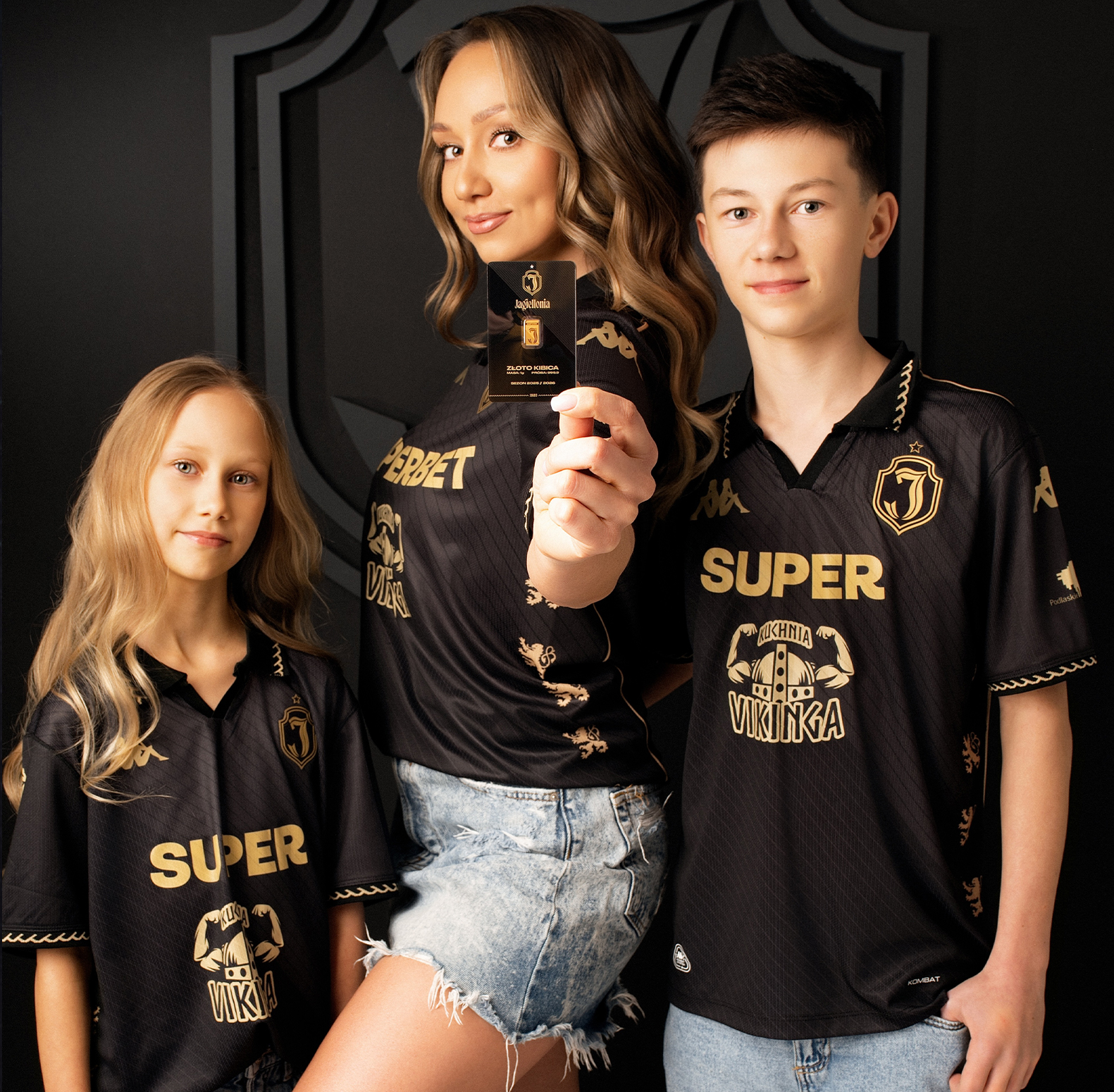 hand holding 1 gram gold bar with Jagiellonia Białystok stadium blurred in background, lifestyle photography